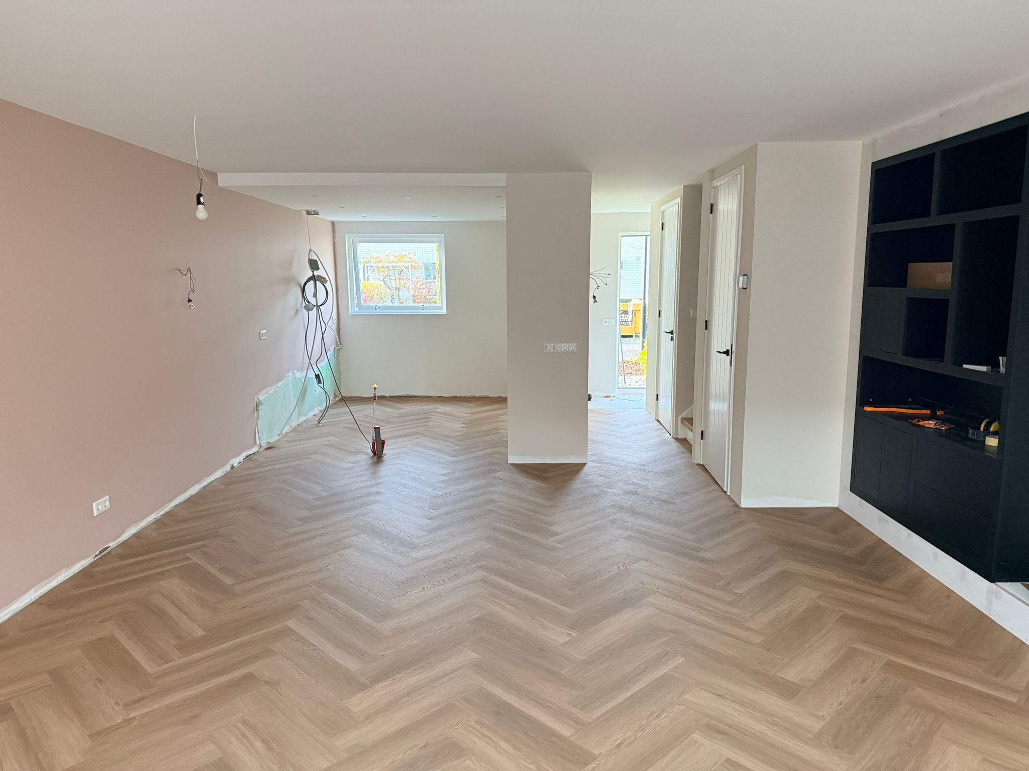 Visgraat met roze muur en zwarte kast